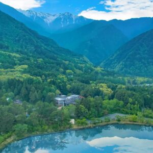 Lakeside ryokan nestled in forest with distant mountain peaks, Suzuranso Nagano