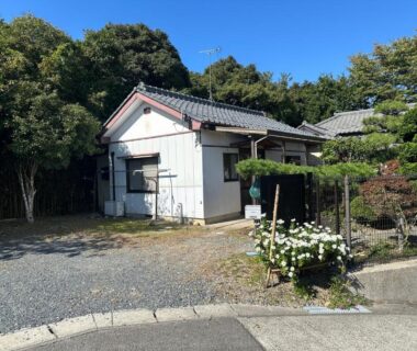 Single-story ryokan exterior with tiled roof, gravel driveway and clipped garden near trees in Miyagi, Tōhoku