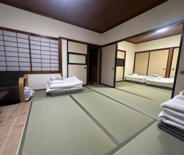 Spacious tatami room with stacked futon bedding and shoji screens at Suzuya ryokan in Miyagi, Tōhoku, Japan