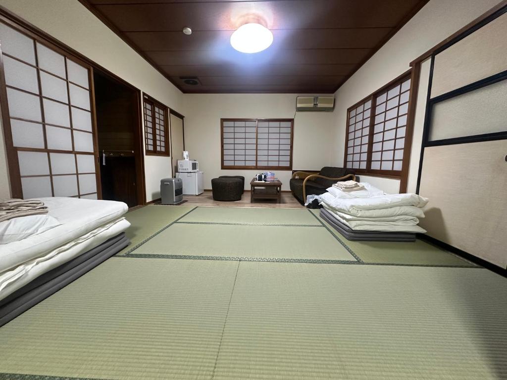 Tatami Room at Suzuya Miyagi Spacious tatami room with futons, shoji screens, small table and chairs at Suzuya in Miyagi Tōhoku