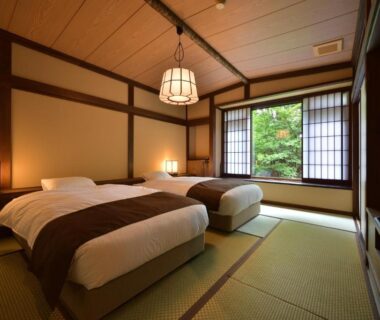 Tatami room with twin beds and shoji screens overlooking greenery at Syoubun in Gunma