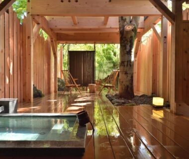 Wooden bathing area with soaking tubs, lanterns and garden view at Syoubun Gunma