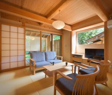 Bright tatami sitting room with shoji screens, wooden beams, low table and lounge seating at Syoubun in Gunma