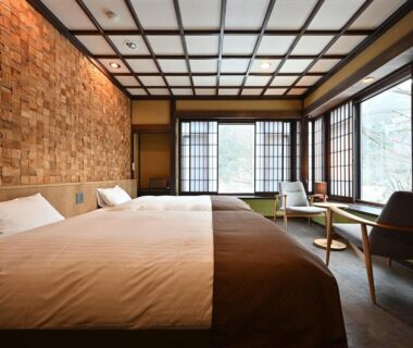 Spacious tatami room with twin beds, shoji screens, wooden lattice ceiling and low seating by large windows