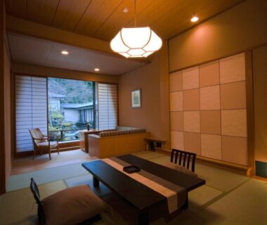 Tatami room with low table, shoji screens and garden view at TAKITEI Riverside Onsen in Ishikawa