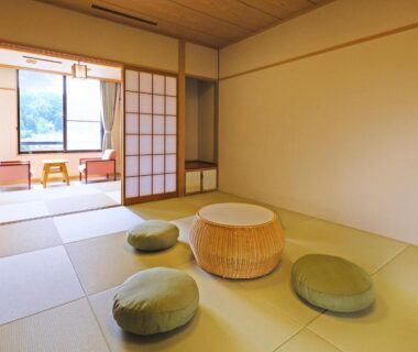 Tatami room with low wicker table, floor cushions and window seating at TAOYA Akiu, Miyagi Tōhoku Japan