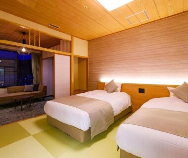 Spacious tatami bedroom with twin beds, shoji screens, seating area and warm wooden ceiling at TAOYA Akiu in Miyagi
