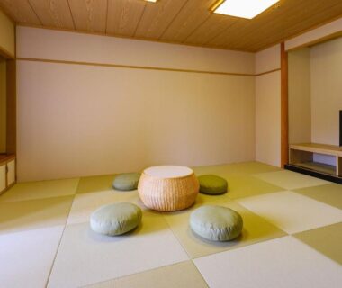 Tatami room with low round table and floor cushions, shoji screens, interior at TAOYA Akiu, Miyagi, Tōhoku, Japan
