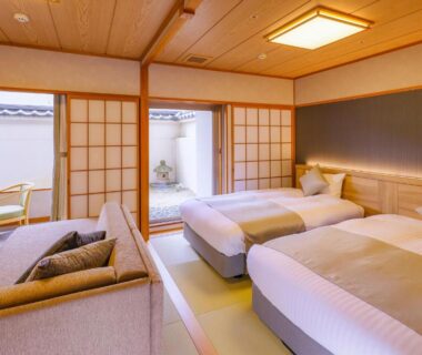 Tatami room with two beds, shoji screens and seating area at TAOYA Akiu in Miyagi