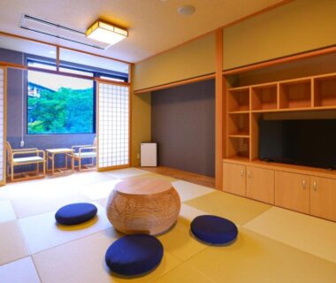 Tatami room with low table, floor cushions and shoji window overlooking green trees at TAOYA Nasu Shiobara
