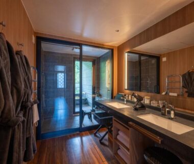Bathroom with wooden soaking tub, double vanity, glass sliding door and bathrobes at THE YUKAWA Ichijoh Branch Miyagi