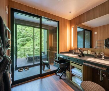 Wood-paneled room with vanity, robes and balcony overlooking trees at THE YUKAWA Ichijoh Branch, Miyagi