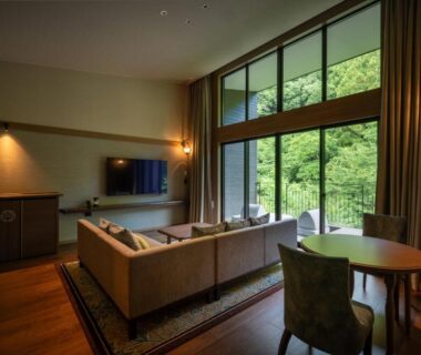 Lounge with sofa, TV and large windows overlooking greenery at THE YUKAWA Ichijoh Branch, Miyagi, Tōhoku