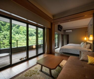 Room with balcony, sofa and bed overlooking forest at THE YUKAWA Ichijoh Branch, Miyagi Tōhoku