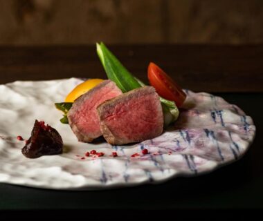 Seared beef slices with seasonal vegetables on textured ceramic plate for ryokan dining at TSUCHIYA Kinosaki Hyōgo