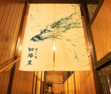 Noren with bamboo painting hanging in wood-paneled entrance corridor at Tabataya ryokan Niigata Chubu