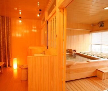 Indoor wooden bathing room with large tub at Tabinoyado Ushionoakari Geiboso in Mie