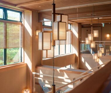 Sunlit hanging lanterns and wooden stairwell at Tabist Chikuba Shinyotei Hakodate Yunokawaonsen in Hokkaidō, Japan