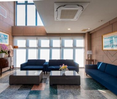 Bright lounge with blue sofas and low tables at Tabist Daibou Ichihara in Chiba, Kantō, Japan