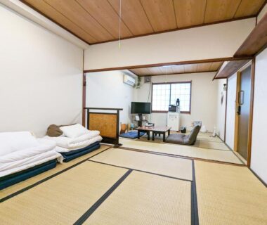 Spacious tatami room with folded futons, low table and seating at Tabist Hamanako no Yado Kosai, Shizuoka