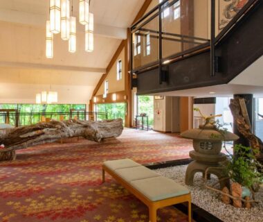 Spacious lobby with bench seating, stone lantern, indoor rock garden and mezzanine at Tabist Koboshi no Yu Senshintei in Fukushima