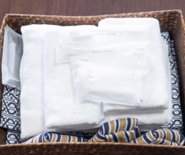 Folded towels and wrapped amenities in a wicker basket at Tabist Miyoshi Ryokan, Odawara, Kanagawa
