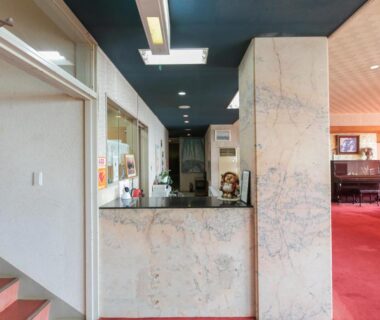 Marble front desk and lobby with red carpet and piano at Tabist Setouchinoyado Takehara Seaside, Hiroshima