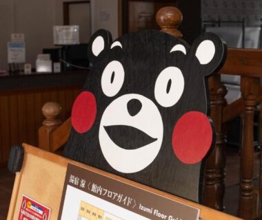 Kumamon mascot cutout at reception desk inside Tabist Yamaga Onsen Yuyado Izumi, Kumamoto