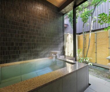 Tiled indoor onsen bath with courtyard garden at Tachibanaya in Yamagata
