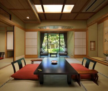 Tatami room with low table, zabuton cushions, shoji screens and garden view at Tachibanaya in Yamagata