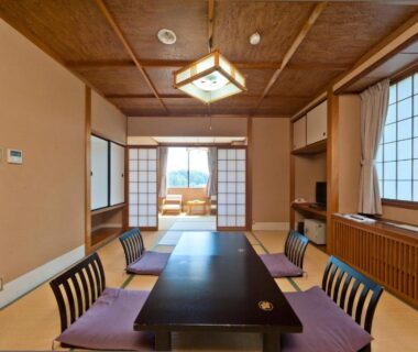 Tatami room with low table, floor chairs, shoji screens and wooden ceiling at Tagawa Ryusenkaku in Ishikawa
