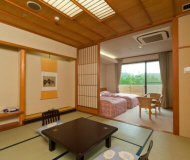 Tatami seating and low table with adjacent beds at Tagawa Ryusenkaku in Ishikawa, Chūbu, Japan