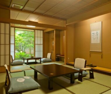 Traditional tatami room with low table, shoji screens and garden view at Tagawa Ryusenkaku in Ishikawa