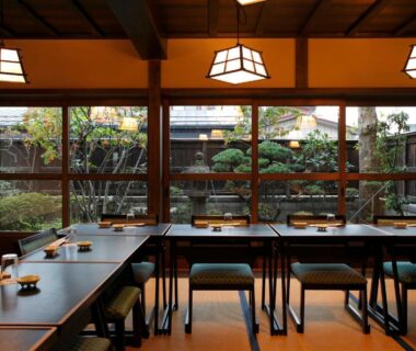 Dining room with low tables, cushions, and garden view at Tagoto in Fukushima Tōhoku