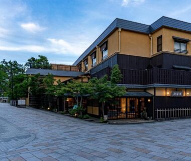 Evening exterior of Taikyourou with wooden facade, entrance lanterns and paved walkway in Kyoto