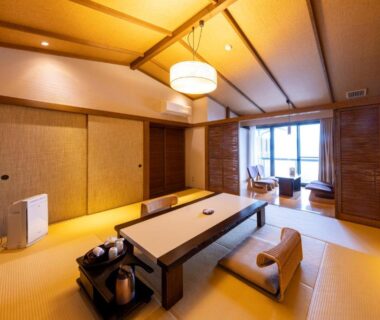 Tatami room with low table, floor chairs and balcony seating at Taiseikan in Shizuoka, Chūbu, Japan