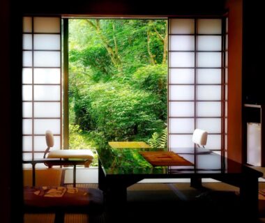 Traditional tatami room with low table, shoji screens and lush garden view at Taishoya in Saga, Kyushu