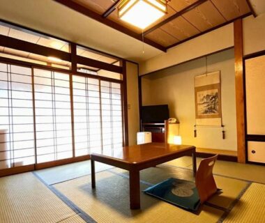 Traditional tatami room with low table, zabuton seating, shoji screens and tokonoma at Taiyokan in Gunma