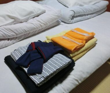 Futon with folded yukata and towels on tatami at Tajimaya in Gifu