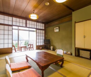 Traditional tatami room with low table, floor cushions, shoji screens and balcony at Takahan, Niigata, Chūbu, Japan