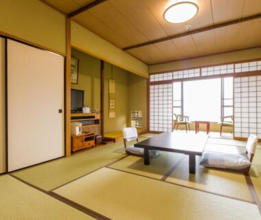 Tatami room with low table, zabuton chairs and shoji screens at Takahan in Chūbu, Niigata
