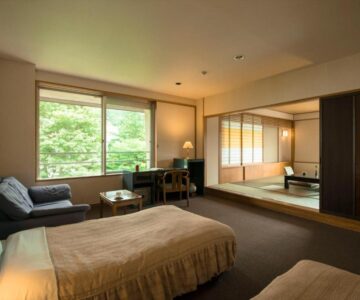 Room with twin beds, tatami area, shoji screens and garden greenery at Takamiya Hotel Lucent, Yamagata