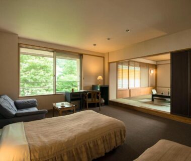 Room with twin beds, tatami area, shoji screens and garden greenery at Takamiya Hotel Lucent, Yamagata