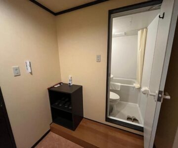 Small genkan and compact bathroom with glass door at Takamiya Hotel Lucent in Yamagata Tōhoku