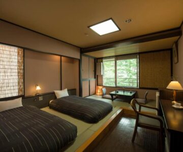 Tatami room with twin low beds, shoji screens and tree views at Takamiya Hotel Lucent in Yamagata, Tohoku