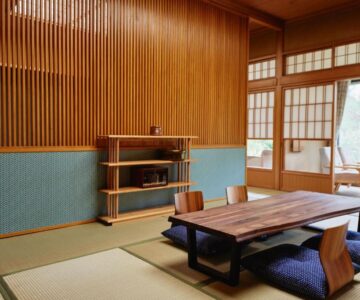 Traditional tatami room with low wooden table, floor cushions, shoji screens and garden-view veranda at Takamiya Ryokan Sagiya Sansorai