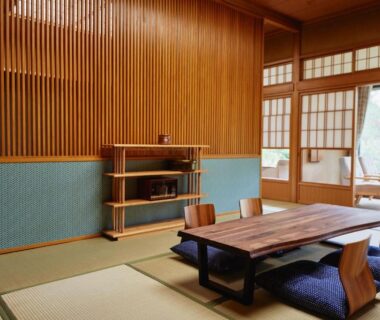 Traditional tatami room with low wooden table, floor cushions, shoji screens and garden-view veranda at Takamiya Ryokan Sagiya Sansorai