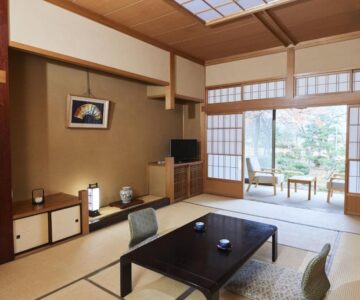 Traditional tatami room with low table, shoji screens and garden view at Takamiya Ryokan Sagiya Sansorai, Yamagata