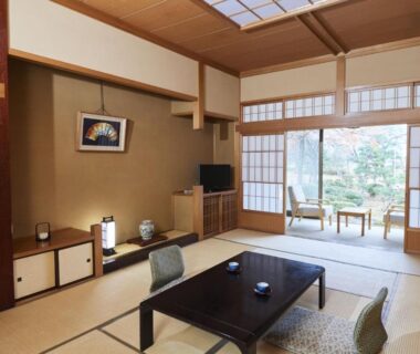 Traditional tatami room with low table, shoji screens and garden view at Takamiya Ryokan Sagiya Sansorai, Yamagata