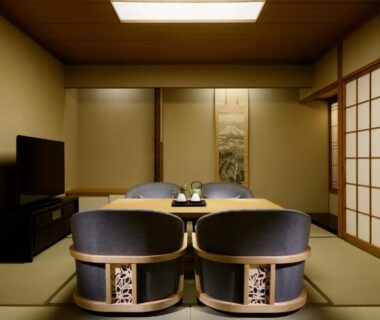 Traditional tatami room with low table, two cushioned floor chairs, shoji screens and alcove scroll at Takanawa Hanakohro
